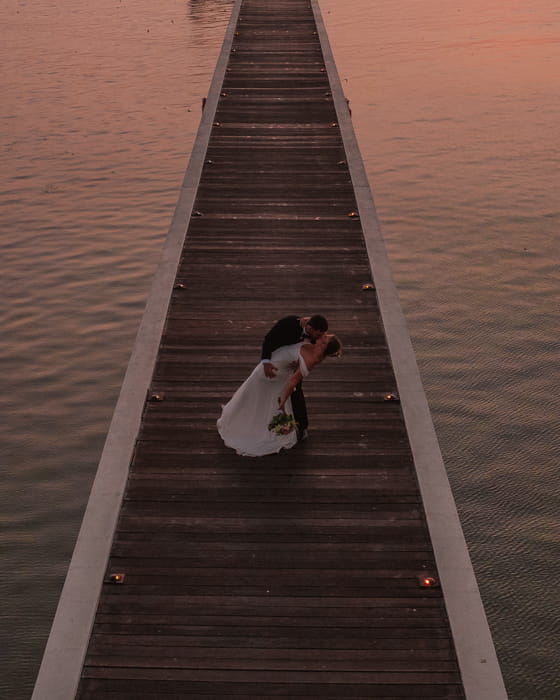 Bride and groom on a pier at sunset in Thailand